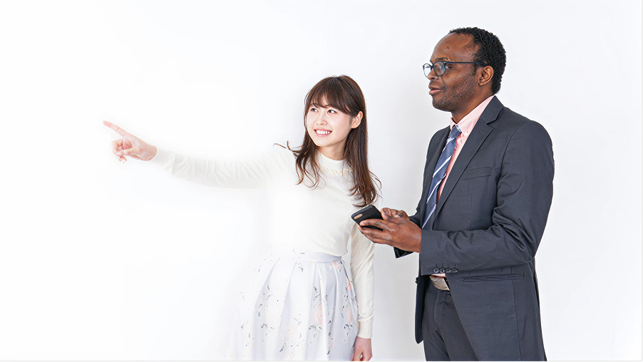 外国人観光客に道案内をしている女性。]