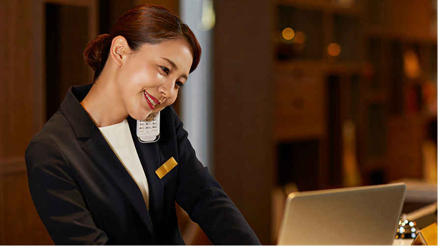 ホテルのフロントで電話を受ける女性。